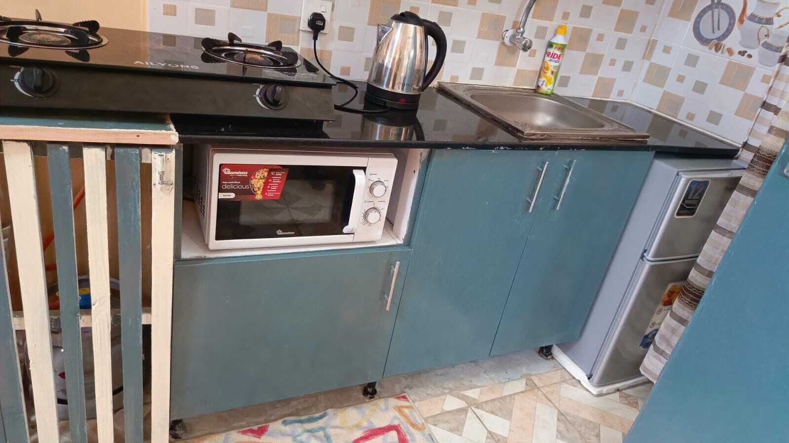 A compact kitchen with a built-in microwave, a gas stove, and a sink.