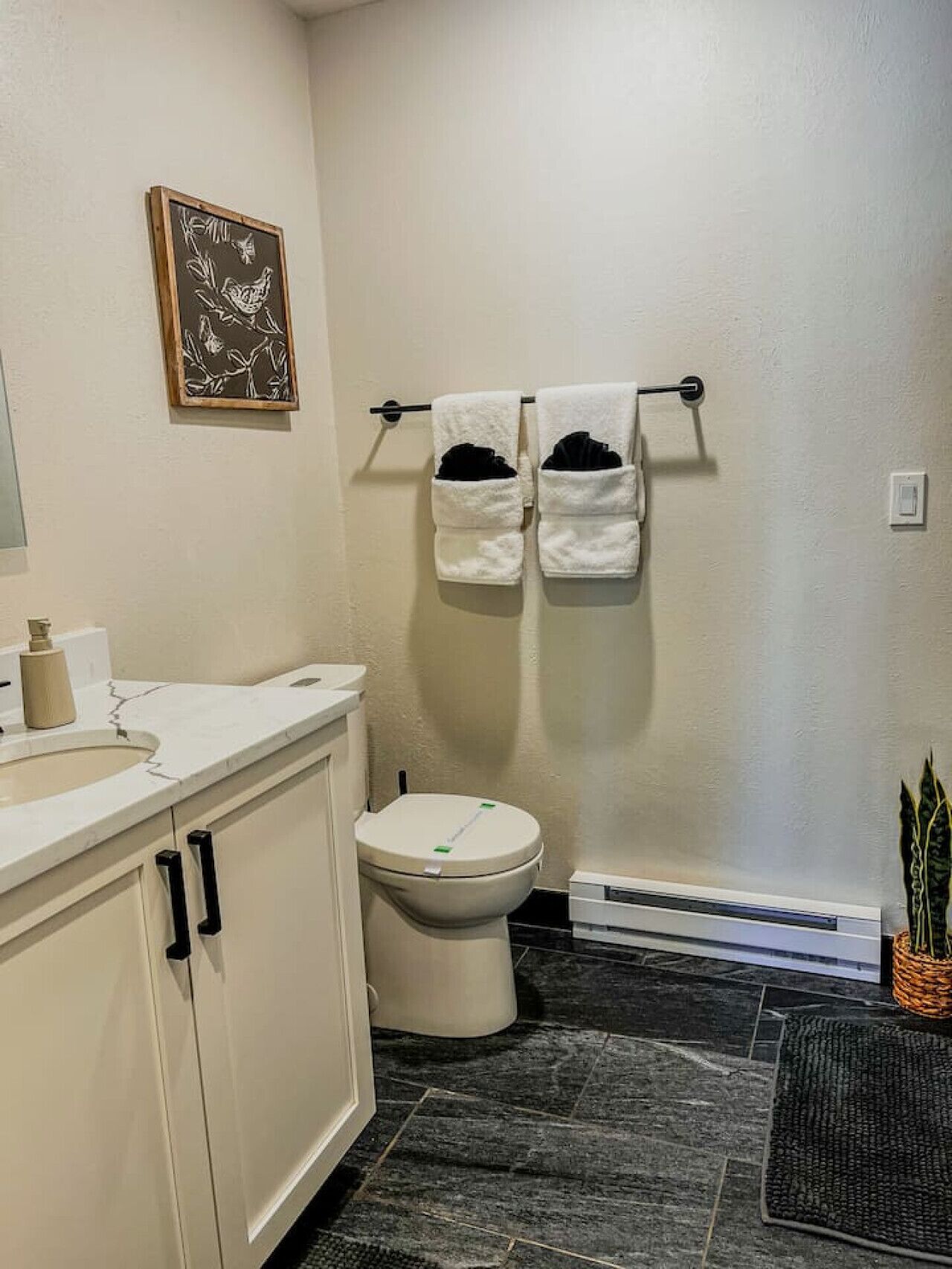 A bathroom with a toilet, sink, and towel rack.