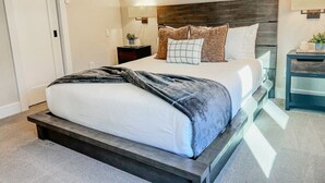 A bedroom with a bed, bedside tables, and a nightstand.