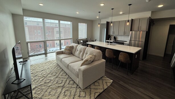 A modern apartment with a living room, kitchen, and dining area.