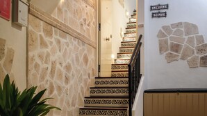 Una scala con piastrelle decorate, una pianta in vaso e un cartello con la scritta 'LA VILA FELIZ'.