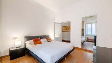 Ein Schlafzimmer mit Bett, Nachttisch und Spiegel.