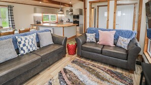 A modern living room with a sofa set, a coffee table, and a patterned rug. - Willow Lodge (Rugeley)