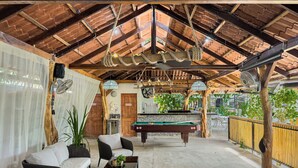 A spacious indoor area with a pool table, comfortable seating, and a high ceiling with exposed beams. - Ela Kosher Hotel and Jewish Center (Jaco)