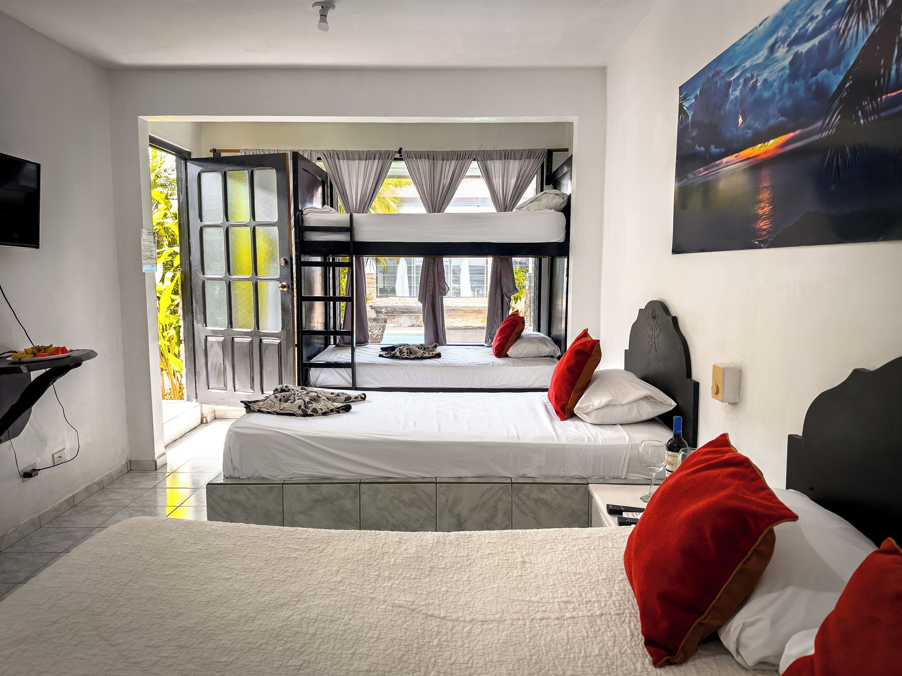 A hotel room with a large bed, a second smaller bed, a TV, and a painting.