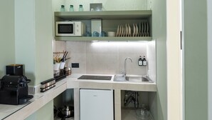 Une cuisine compacte équipée d’un four à micro-ondes, d’une machine à café et d’un petit réfrigérateur.