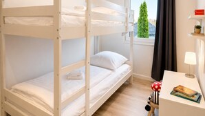 Habitación con literas, escritorio y lámpara.