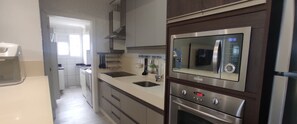 Departamento Deluxe, vista a la playa | Cocina privada | Refrigerador, microondas y utensilios de cocina 