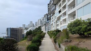 A modern apartment building with a long, straight pathway leading to the entrance. - Oceana Suites EuroMarina II (Viña del Mar)
