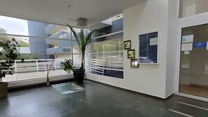 A modern interior with large windows, a glass table, and potted plants. - Oceana Suites EuroMarina II (Viña del Mar)