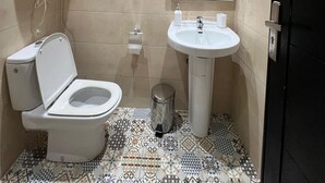 Une petite salle de bain avec des toilettes, un lavabo et un miroir.