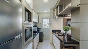 A modern kitchen with stainless steel appliances, a built-in oven, and a window providing natural light. - Apt w/ BBQ & View, 130m From Beach Rsd0202 (Porto Belo)