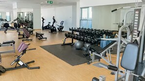 A gym with various exercise equipment, including treadmills, dumbbells, and weight machines. - Luxury 1BR Apartment Near Wolrd Trade Center ALK4 (Dubai)