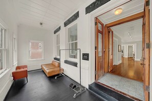 Eine Hotelhalle mit einer Ledersofa, einer Holztür und Blick auf den Flur.