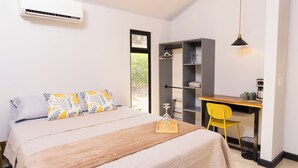 Une chambre à coucher comprenant un lit, une table de chevet et un bureau avec une chaise.