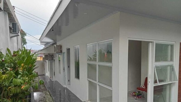 A modern building with large windows and a covered patio area. - Hotel O 95063 Afifah Syariah Guest House Manado (Manado)