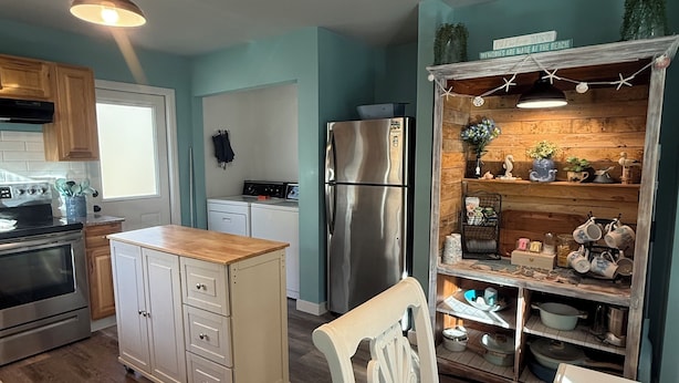 Una cocina con gabinetes de madera, un refrigerador de acero inoxidable y una isla de madera.