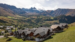 A cluster of wooden chalets with sloped roofs, set against a backdrop of mountains and a valley. - Apartment for 4 - 6 people in Albiez-Montrond (Albiez-Montrond)