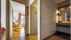 A hallway with wooden flooring leading to a bedroom with a bed and a window. There is a door with a nameplate and a radiator in the bathroom. - Apartment for 4 - 6 people in Albiez-Montrond (Albiez-Montrond)