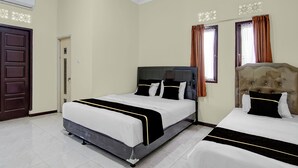 A hotel room with a large bed, a smaller bed, a wardrobe, a door, and a window with curtains. - Capital O 95046 Gefa Sleep N Go (Pekanbaru)