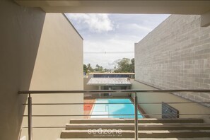 A view from a balcony overlooking a swimming pool, with a staircase leading down to a lower level. - House w/ Pool and Barbecue Grill Thg0006 (Porto Seguro)