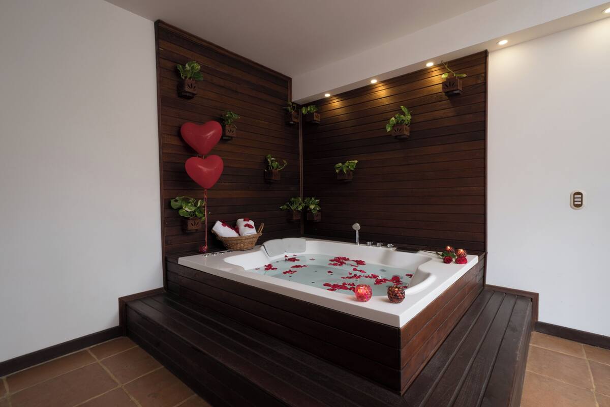 Ein modernes Badezimmer mit freistehender Badewanne, Holzvertäfelung und Topfpflanzen.