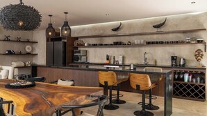 Une cuisine moderne avec une table à manger en bois, des tabourets de bar et un meuble à vin.