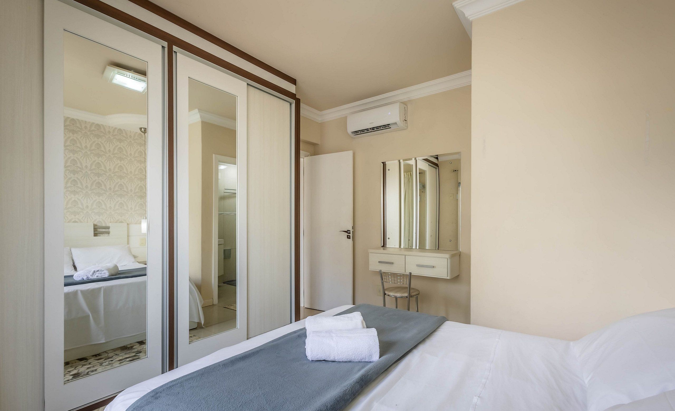 Una habitación de hotel con cama, baño y puerta corrediza que da a otra habitación.