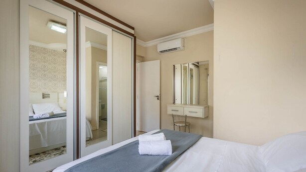 A hotel room with a bed, a bathroom, and a sliding door leading to another room. - Apts Just 210m From the Beach in Balneario Camboriu - Edis (Balneário Camboriú)