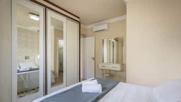 Una habitación de hotel con cama, baño y puerta corrediza que da a otra habitación.