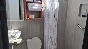Un baño moderno con inodoro, lavamanos y zona de ducha.