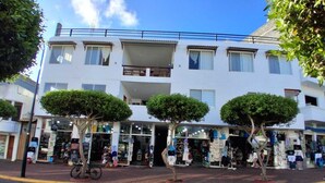 Un edificio de dos plantas con una tienda en la planta baja y un balcón en el segundo piso.