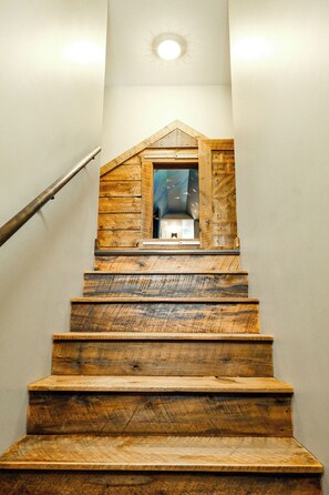 A wooden staircase with a built-in bench at the top, leading to a room with a starry wall design. - Family Fun · Indoor Play Zone · UP Waterfalls (Bessemer)
