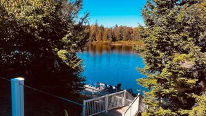 A wooden dock leading to a lake surrounded by trees.