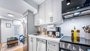 Una cocina moderna con electrodomésticos de acero inoxidable, lavavajillas y horno empotrado.