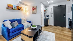 Ein modernes Wohnzimmer mit einem blauen Sofa, einem Couchtisch und einem schwarzen Schrank.