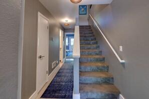 A hallway with a carpeted staircase leading to a door. - Bar7K Our Jackson Townhouse Hideaway -Walk to Town (Jackson)
