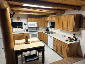 Une cuisine de taille réduite, dotée de meubles en bois, d’un four à micro-ondes, d’une cuisinière et d’un évier.