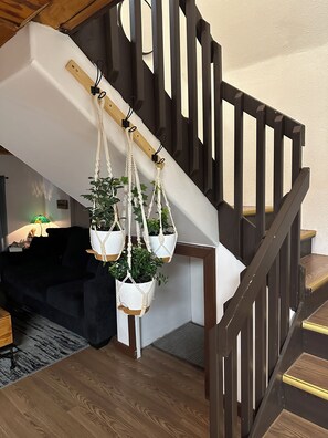 Un escalier avec des rampes en bois et un canapé noir dans la pièce adjacente.