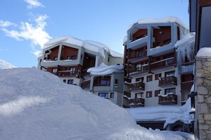 Ein mehrstöckiges Hotel mit Balkonen und einer verschneiten Landschaft.