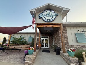A restaurant named 'Breck on the Lake' with an American flag, outdoor seating, and a stone facade.
