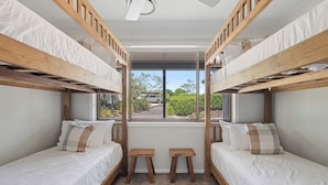 A bunk bed room with a window view, wooden benches, and a ceiling fan. - Moonee Stayz – House - Where Moonee estuary meets the ocean (Moonee Beach)