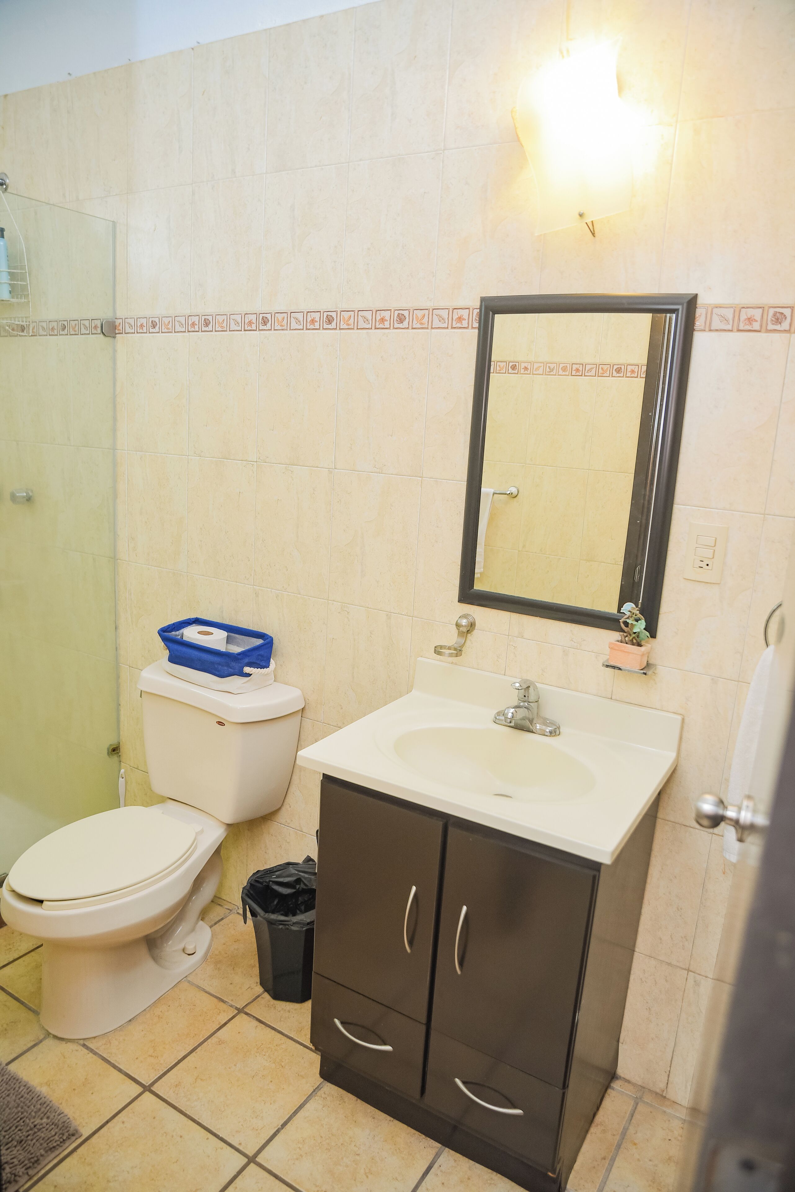 Un baño con inodoro, lavabo y espejo.