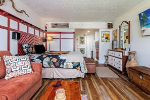 Une chambre à coucher avec un lit, un canapé, une commode et un miroir.