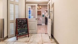 A hallway leading to a cafe with a chalkboard menu listing breakfast items. - Oceans 211 is a colorful newly renovated suite in the popular Oceans Reef resort (Myrtle Beach)