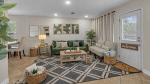 Ein Wohnzimmer mit einer Couch, einem Couchtisch, einer Lampe und einem Willkommensschild.