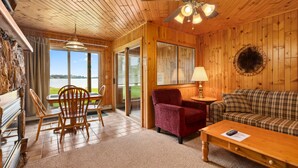 Un intérieur en bois comprenant un canapé, des fauteuils, une table et un ventilateur de plafond.