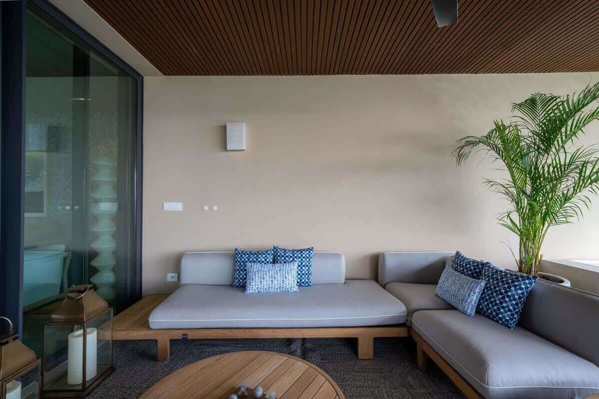 A modern living room with a sectional sofa, a coffee table, and a large plant.