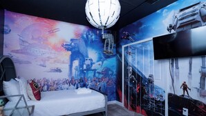 A bedroom with a bed, a wall mural, a TV, and a ceiling light. - 6BR Family at Champions Gate Pool Game Room (Kissimmee)
