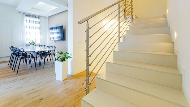 Een modern interieur met een trap, een eethoek en een flatscreen-televisie.